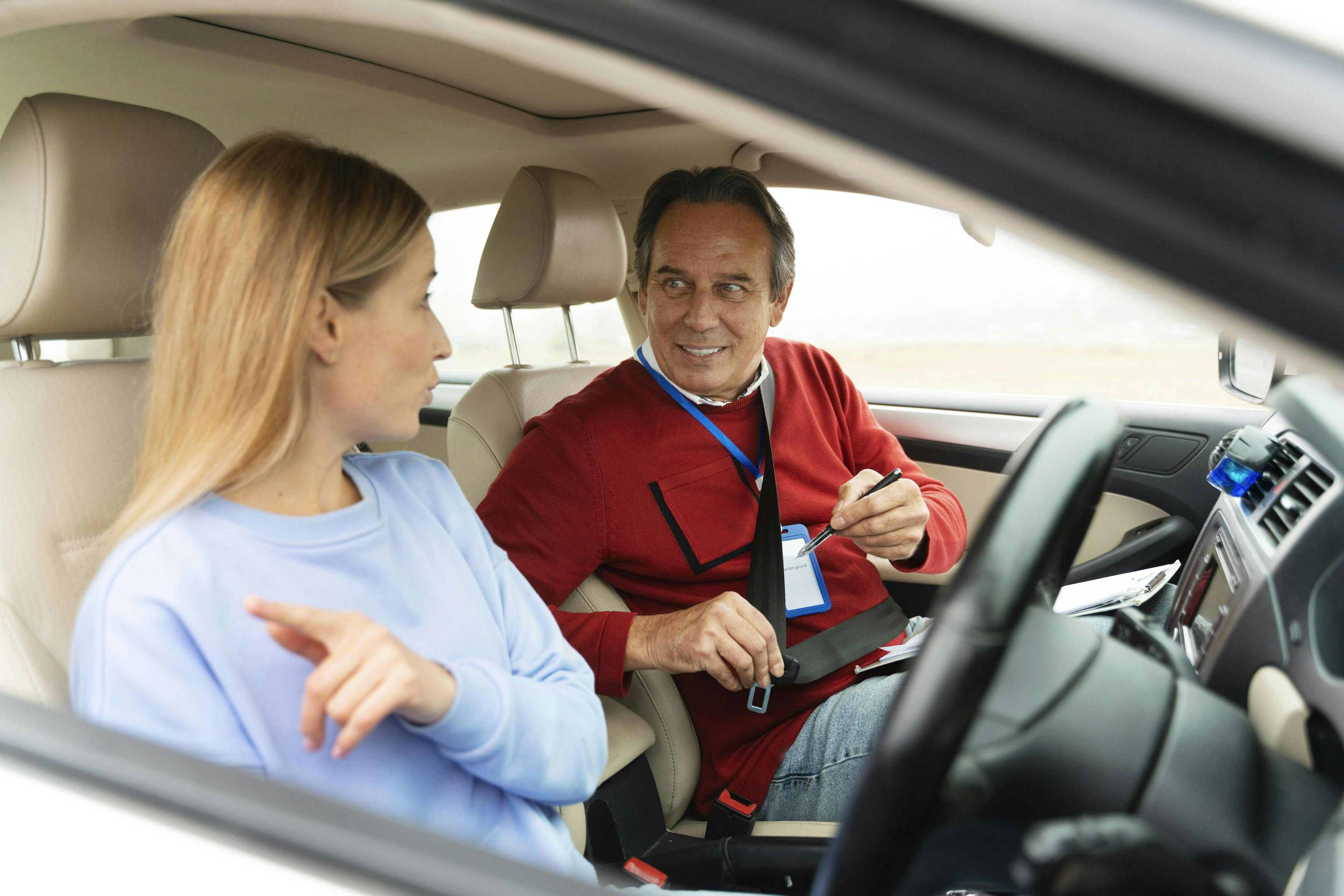 Driving instructor showing their learner cockpit controls during a driving lesson