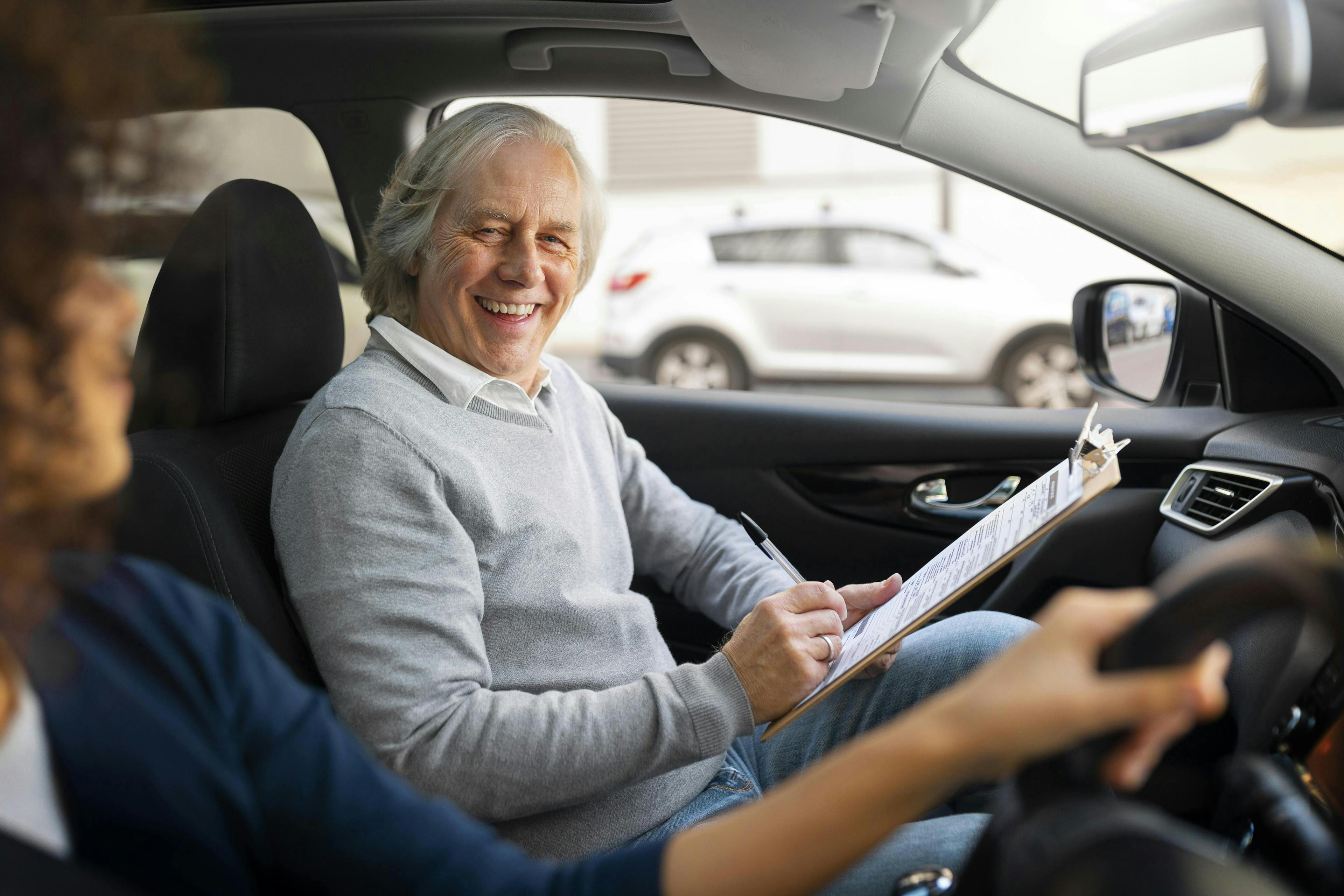 Driving instructor assessing a learner during his standards check test